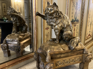 Brass statuette of a cat with a raise paw